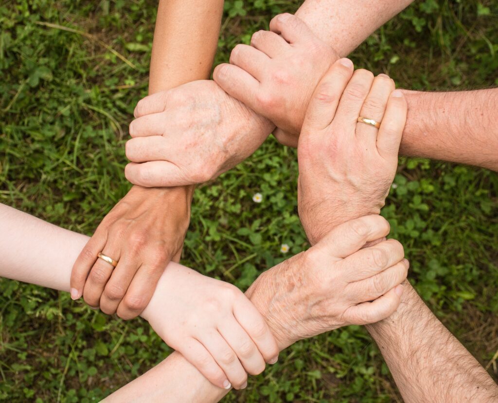 6 hands of people are crossed